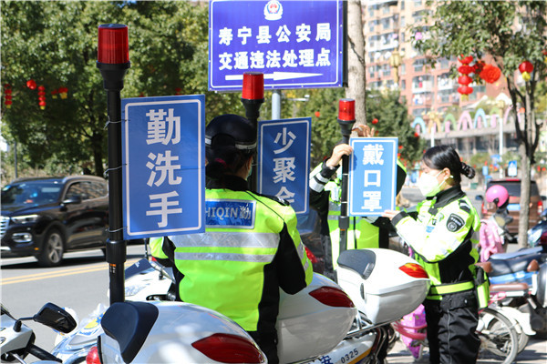 女子骑行中队队员将宣传牌挂在警用摩托车上，准备上街巡逻。.jpg