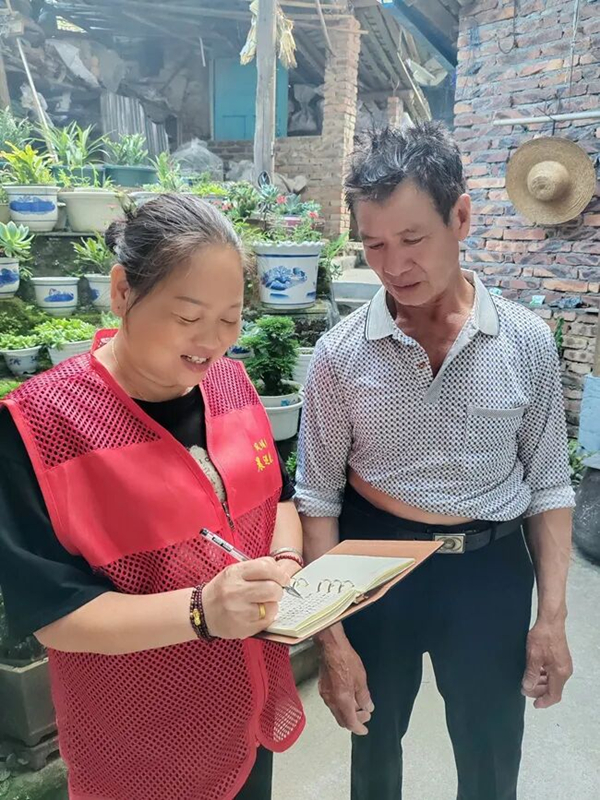 凤埔乡峦龙村党支部书记周丽玲入户记录群众需求。周东海摄.jpg