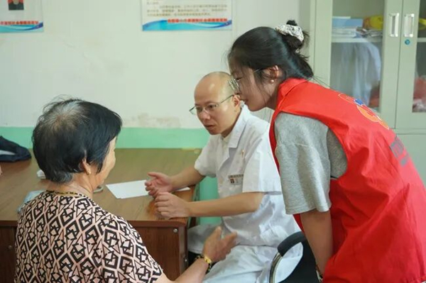 泮洋乡党员志愿者、杜鹃花志愿者在炭洋村化身老人“贴身翻译”，帮助老人与外地医生沟通。朱沁怡摄.jpg